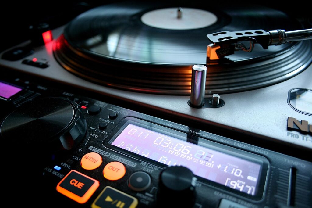 Close-up of a vinyl record spinning on a DJ turntable with the tonearm in focus—visual for beatmatching and transitions